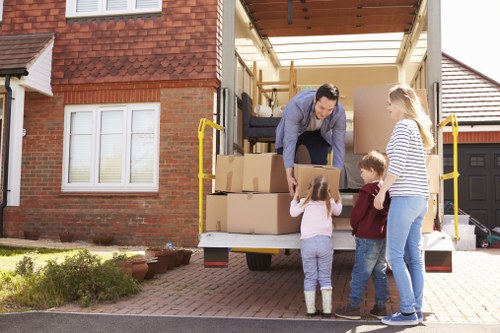 Removal company staff carrying furniture through a Hackney property