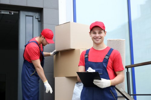 Student moving boxes and furniture in a Hackney street setting