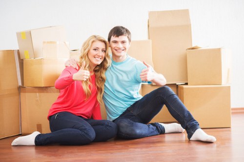 Movers carrying furniture down apartment stairs in Hackney